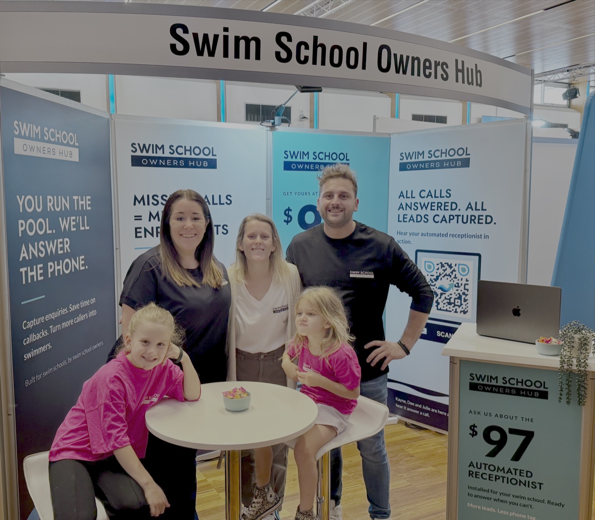 Julie, Kayne and Dee with two of their children on the Swim School Owners Hub stand at SwimCon
